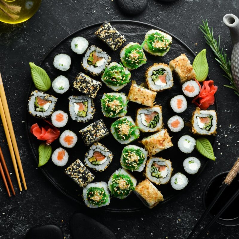 set-traditional-sushi-black-plate-sushi-rolls-dark-background-scaled
